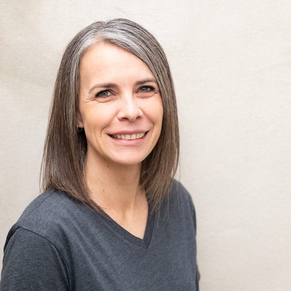 staff-member-4 woman smiles at the camera during professional headshot photos
